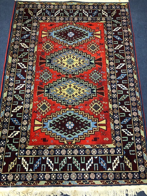 A Caucasian design red ground rug 180 x 126cm